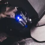 Bluetoothowy skaner OBD podłączony wewnątrz auta w niebieskim świetle