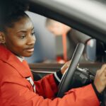 Kobieta w czerwonym płaszczu dotyka ekranu dotykowego na desce rozdzielczej