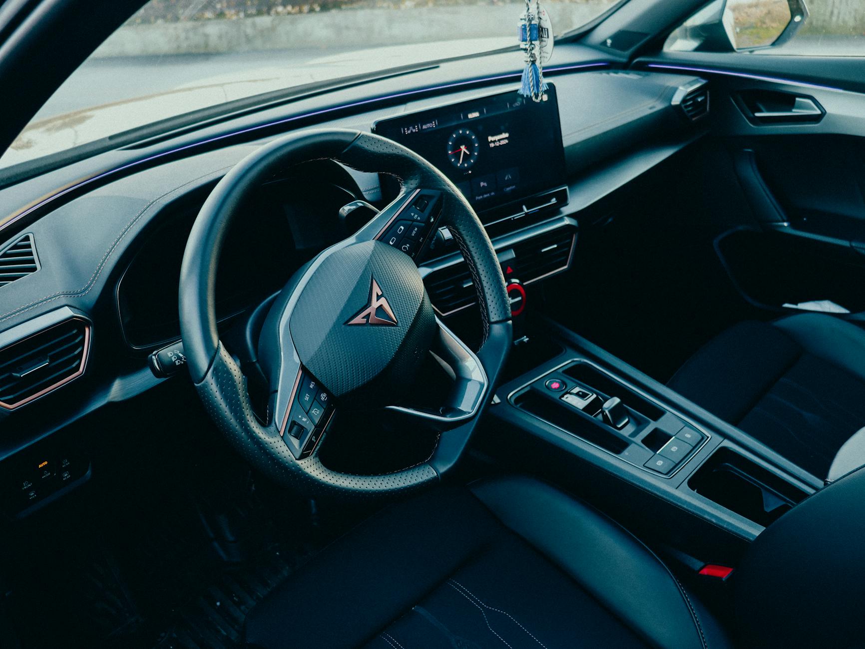 Wnętrze nowoczesnego auta z widokiem na deskę rozdzielczą i kierownicę