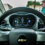 Zbliżenie na deskę rozdzielczą auta z cyfrowym wyświetlaczem i kierownicą