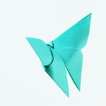 Niebieski papierowy motyl origami na białym tle