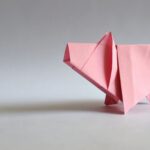 Różowa papierowa świnka origami na jasnym tle