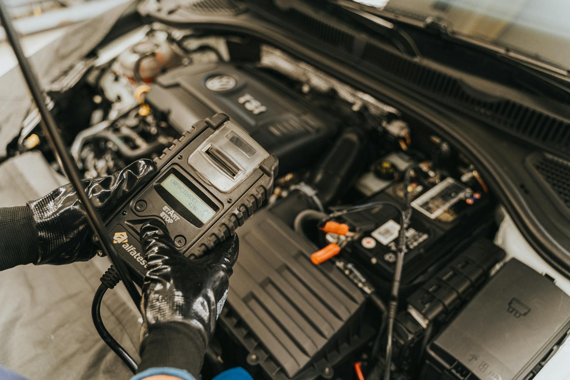 Mechanik diagnozuje silnik samochodu elektronicznym testerem