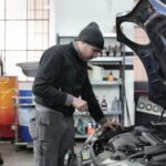 Mechanik sprawdzający silnik samochodu w garażu